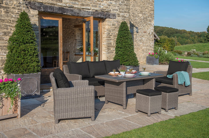 Palma Wicker Rattan Sofa set in outdoor patio with wicker chairs, table, and black cushions for relaxing and dining.