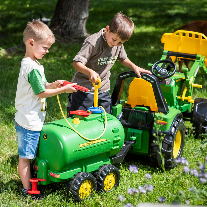 Children playing outdoors with John Deere Water Tanker With Pump & Spray Gun attached to pedal tractor.