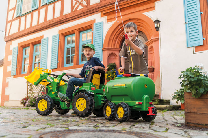 John Deere Water Tanker With Pump & Spray Gun attached to a pedal tractor with kids playing outdoors.
