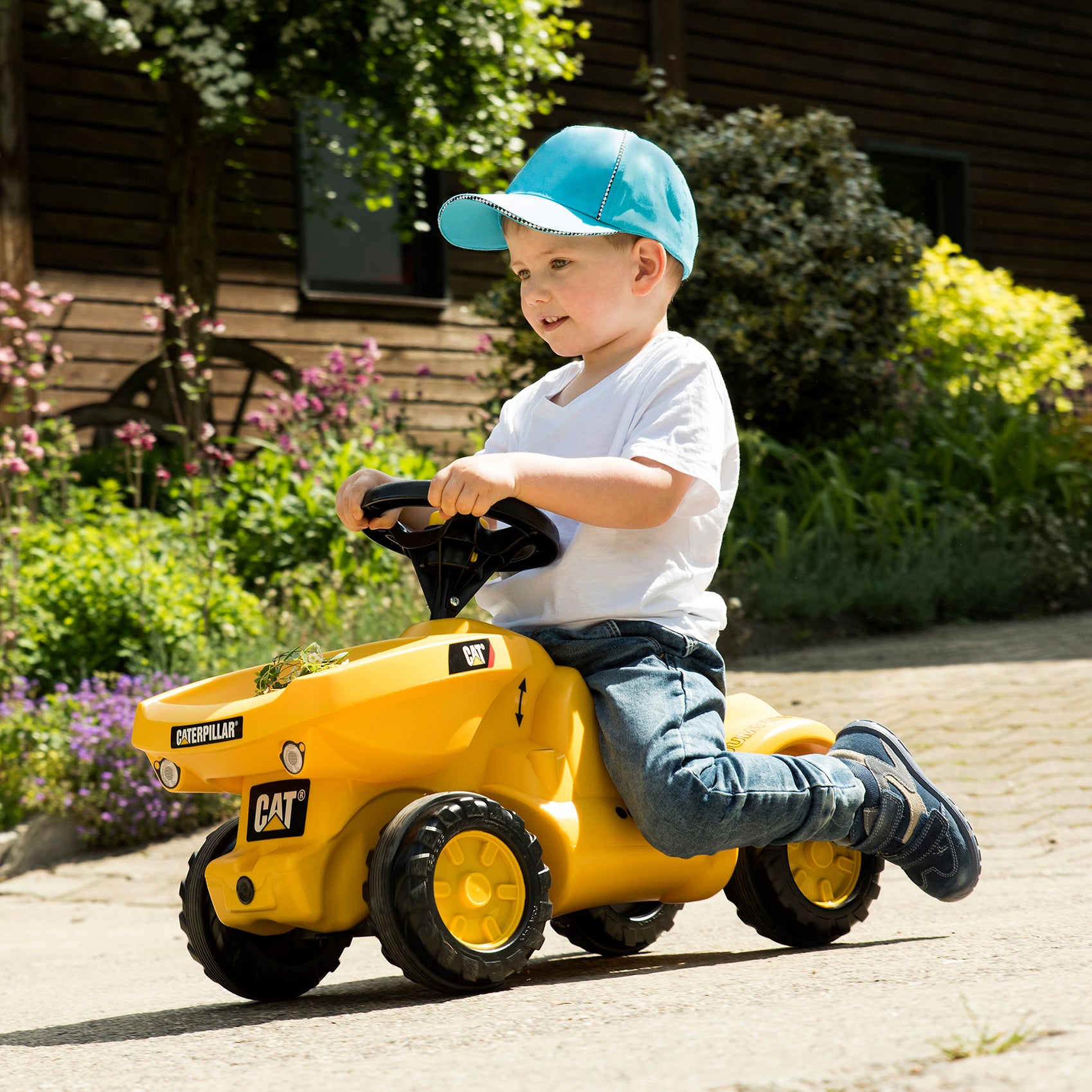 Lifestyle shot of little boy riding made in germany caterpillar foot to floor vehicle