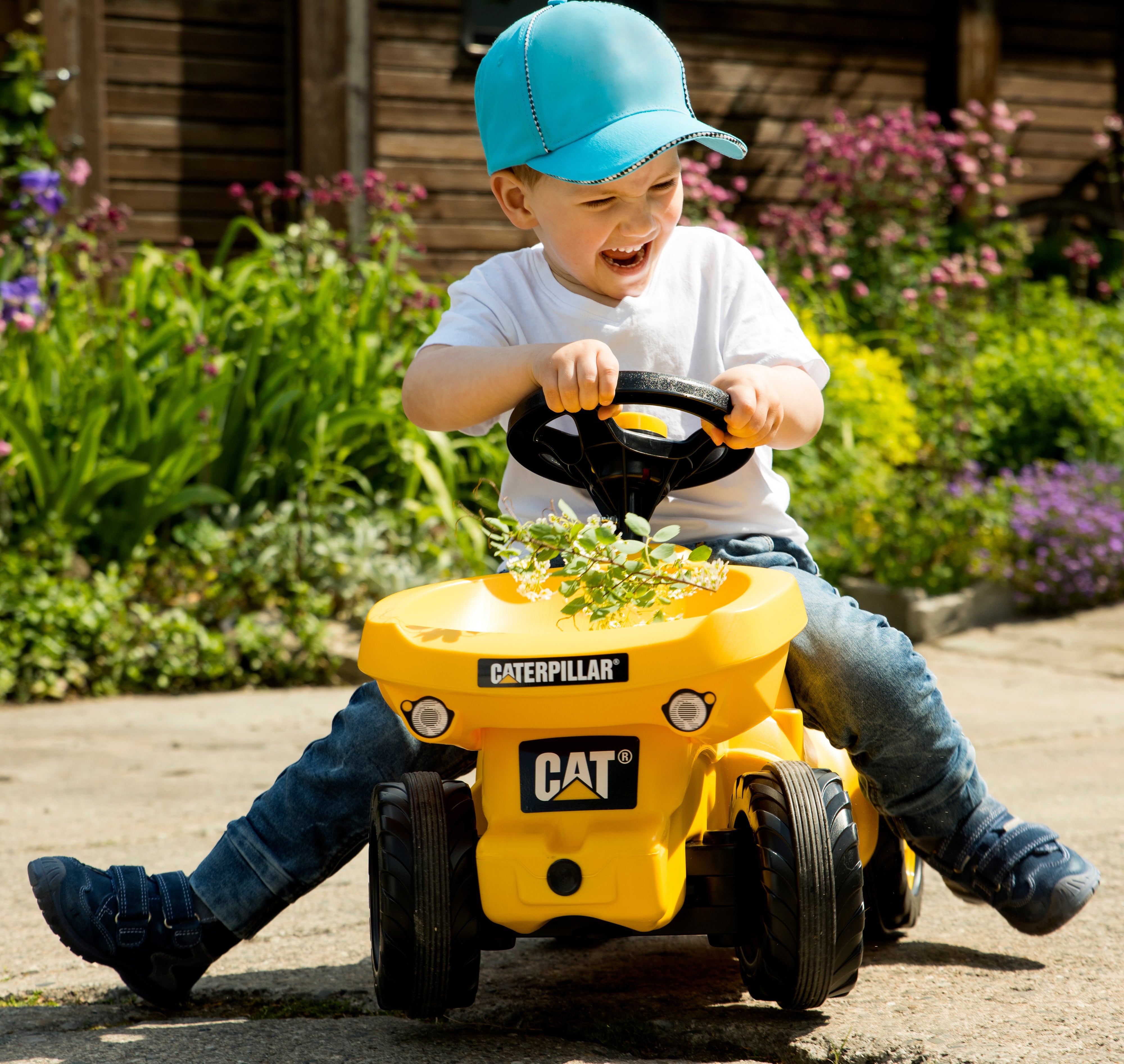 Child riding on foot to floor resin vehicle with load in front loader