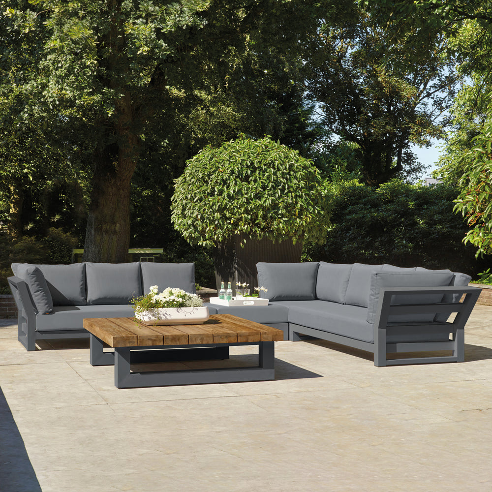 Nevada Large Corner Conversation Set with lava aluminum frame, teak table top, and canvas soot cushions in outdoor patio setting.