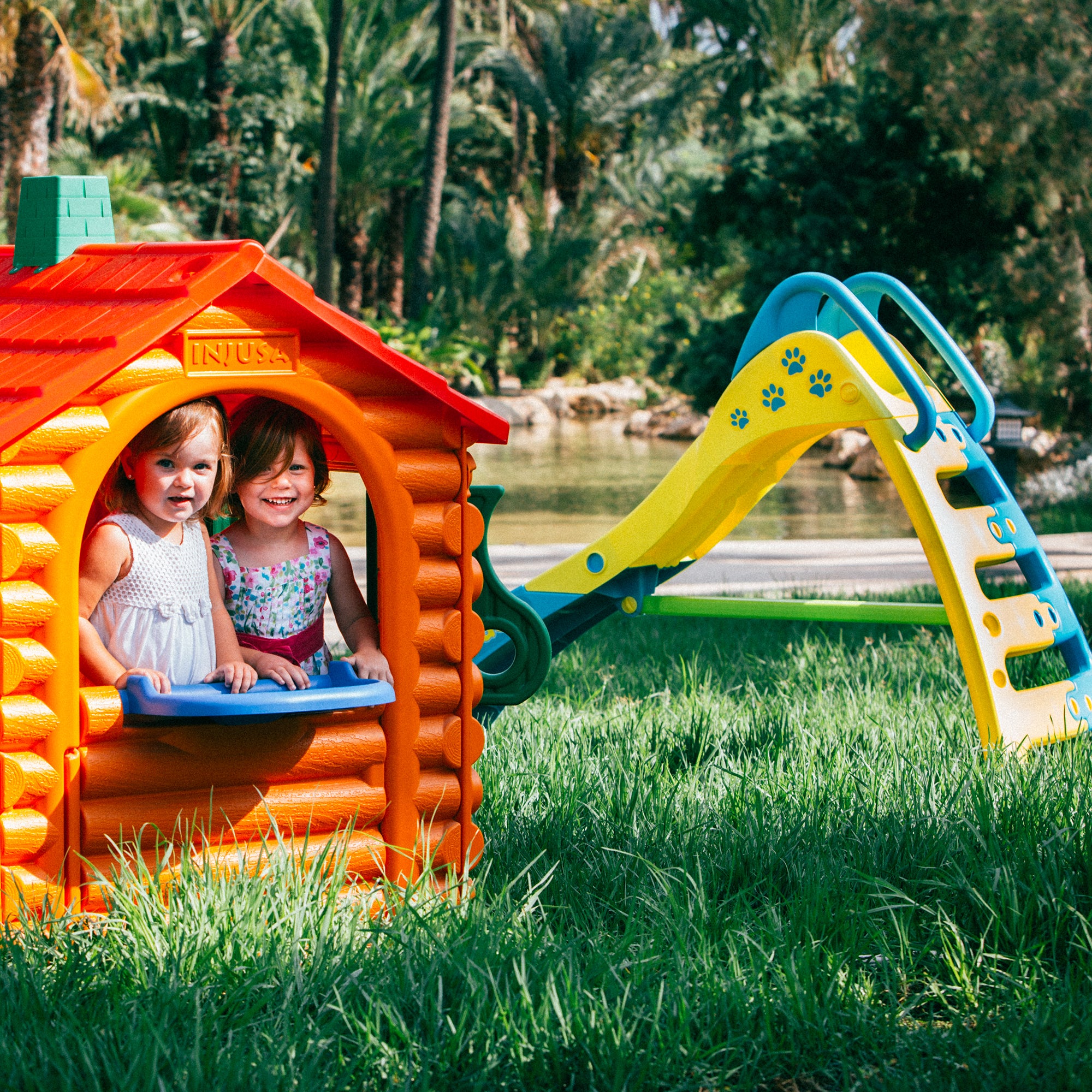 Lifestyle image of little girls playing the INJUSA Resin Hut House.