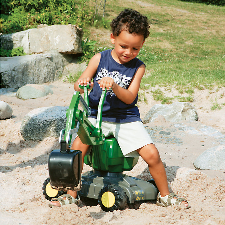 John Deere Ride-On Digger with 360-degree rotation and functional scooping action for kids digging in the sand.