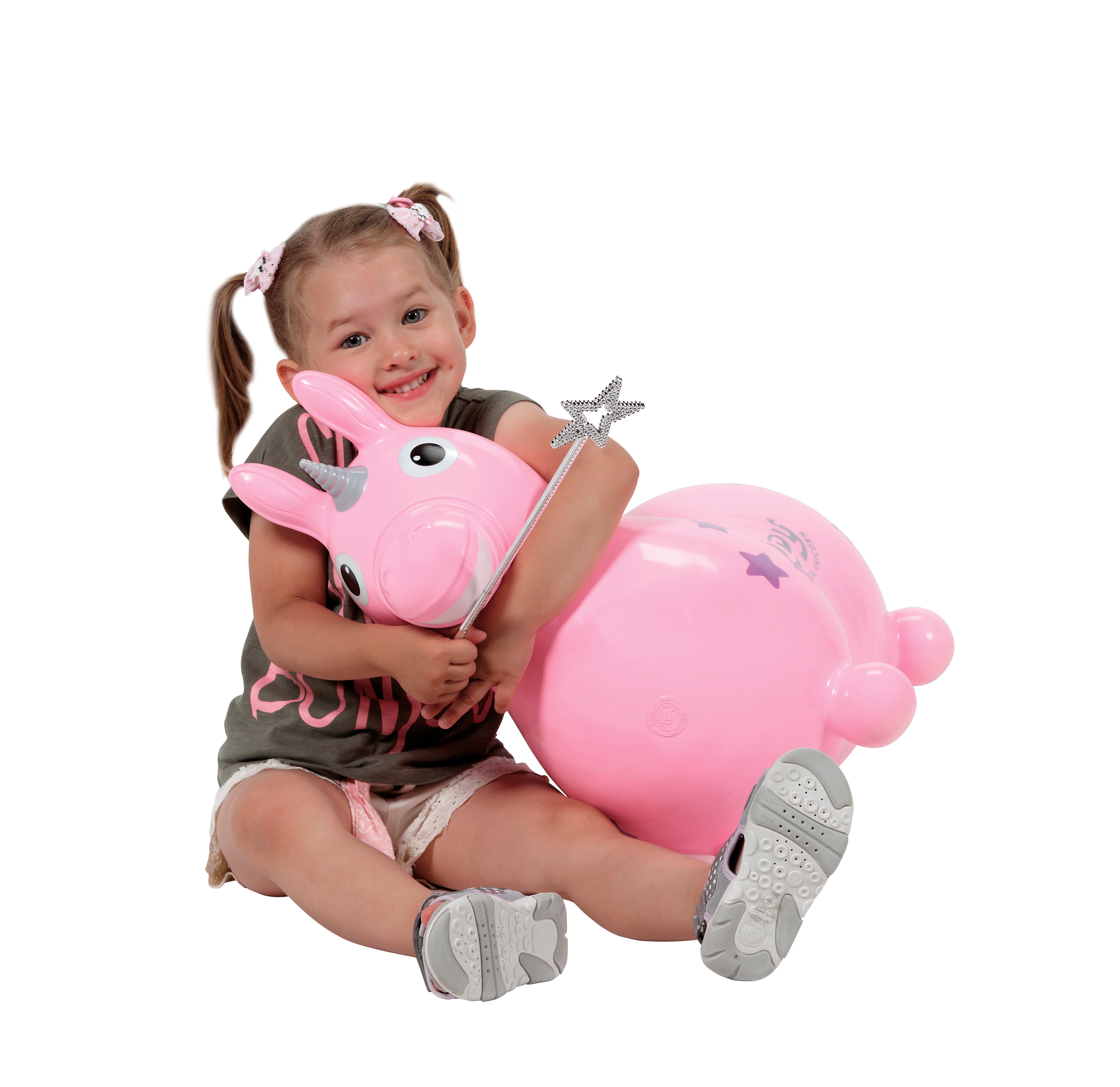 Studio image of a little girl hugging the pink Rody Magical Unicorn while holding a magic wand.