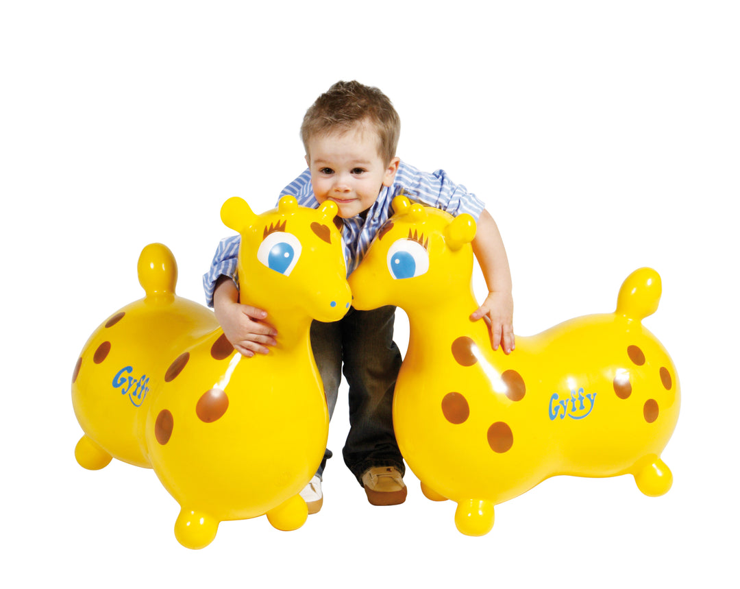 Child playing with two bright yellow Gyffy The Giraffe Bounce Toy With Pump inflatables promoting active playtime.