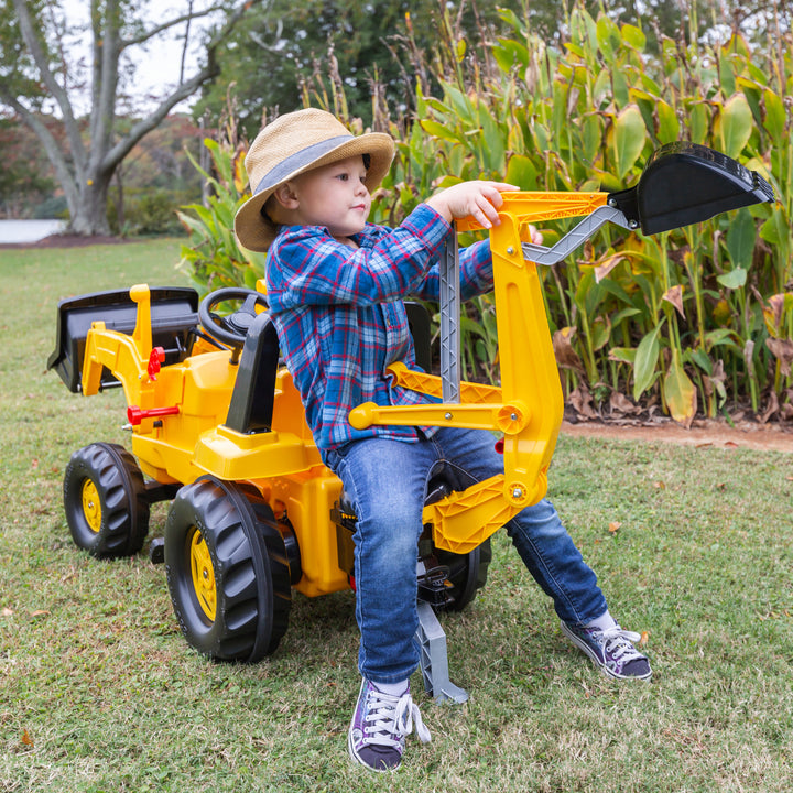 Child playing outdoors on CAT Front Loader With Backhoe Pedal Tractor with functional loader and backhoe attachments