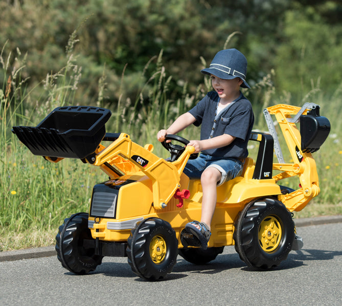 Lifestyle shot of child riding on made in germany pedal tractor caterpillar 