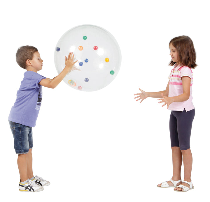 Two children playing with a transparent Gymnic Activity Ball containing colorful balls inside for sensory stimulation.
