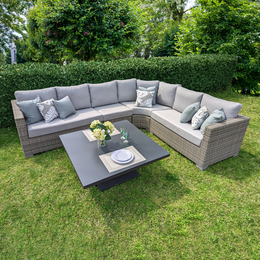 Aya Wicker 5-Piece Corner Sectional With Cushions in yacht grey wicker with grey cushions and adjustable height table outdoors.