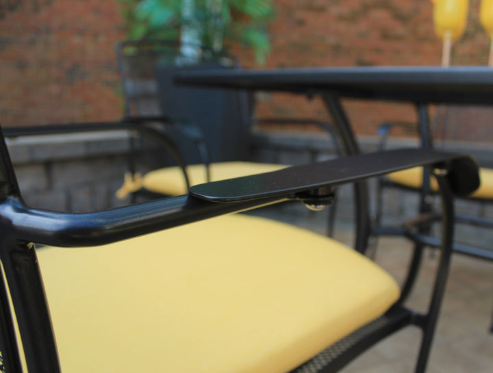 Henley Wrought Iron Mesh Stackable Arm Chair - Set Of 4 with iron grey frame and yellow cushions in outdoor patio setting.