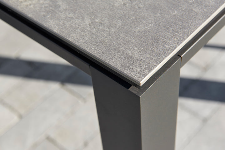 Primavera Coffee Table with ceramic concrete look top and durable lava color aluminum frame close-up on corner.