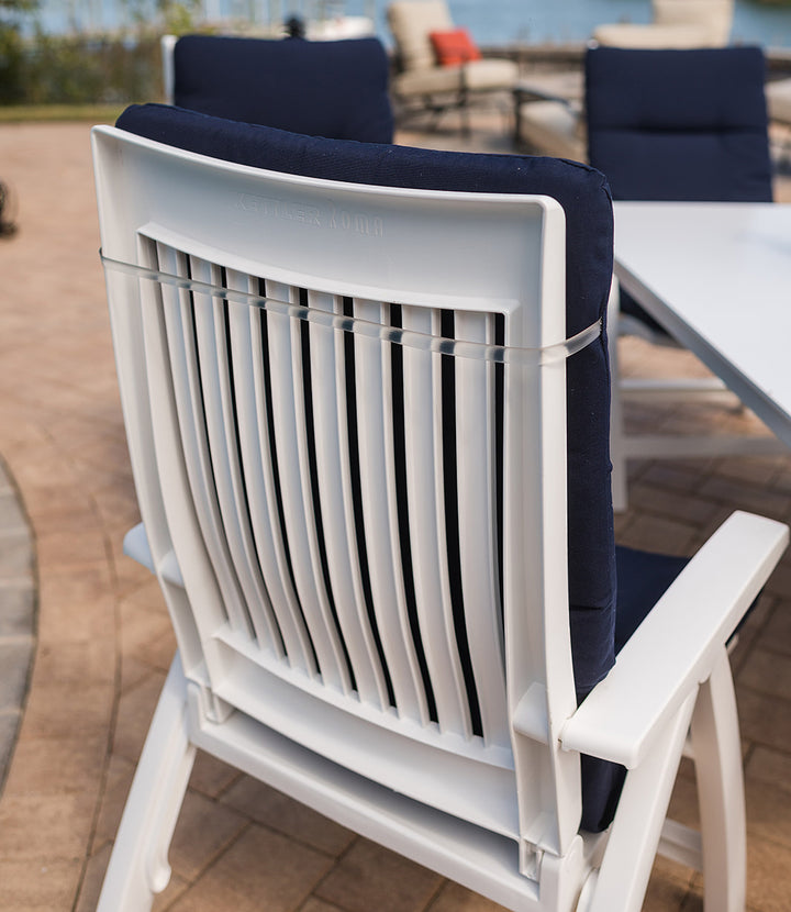 Multi Position Hinged Chair Cushions secured on white outdoor chair with navy blue fabric in patio setting