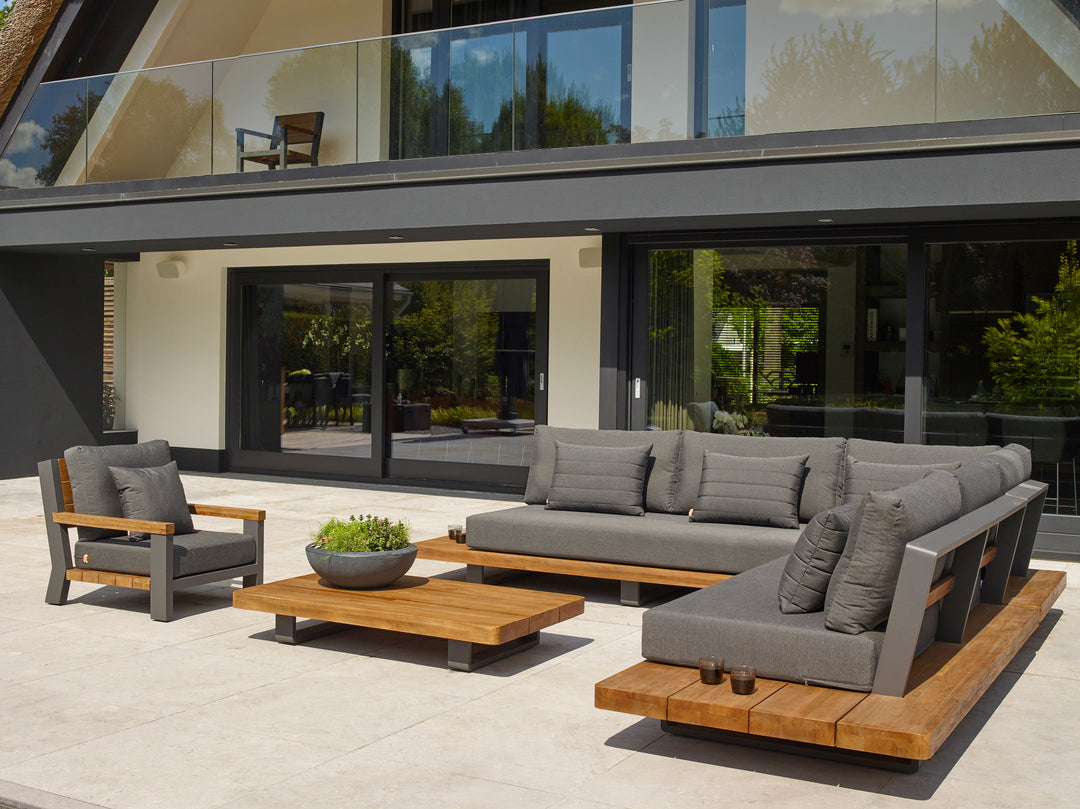 Fitz Roy Teak Corner Set outdoor lounge with modular teak frames and gray all-weather cushions on patio.