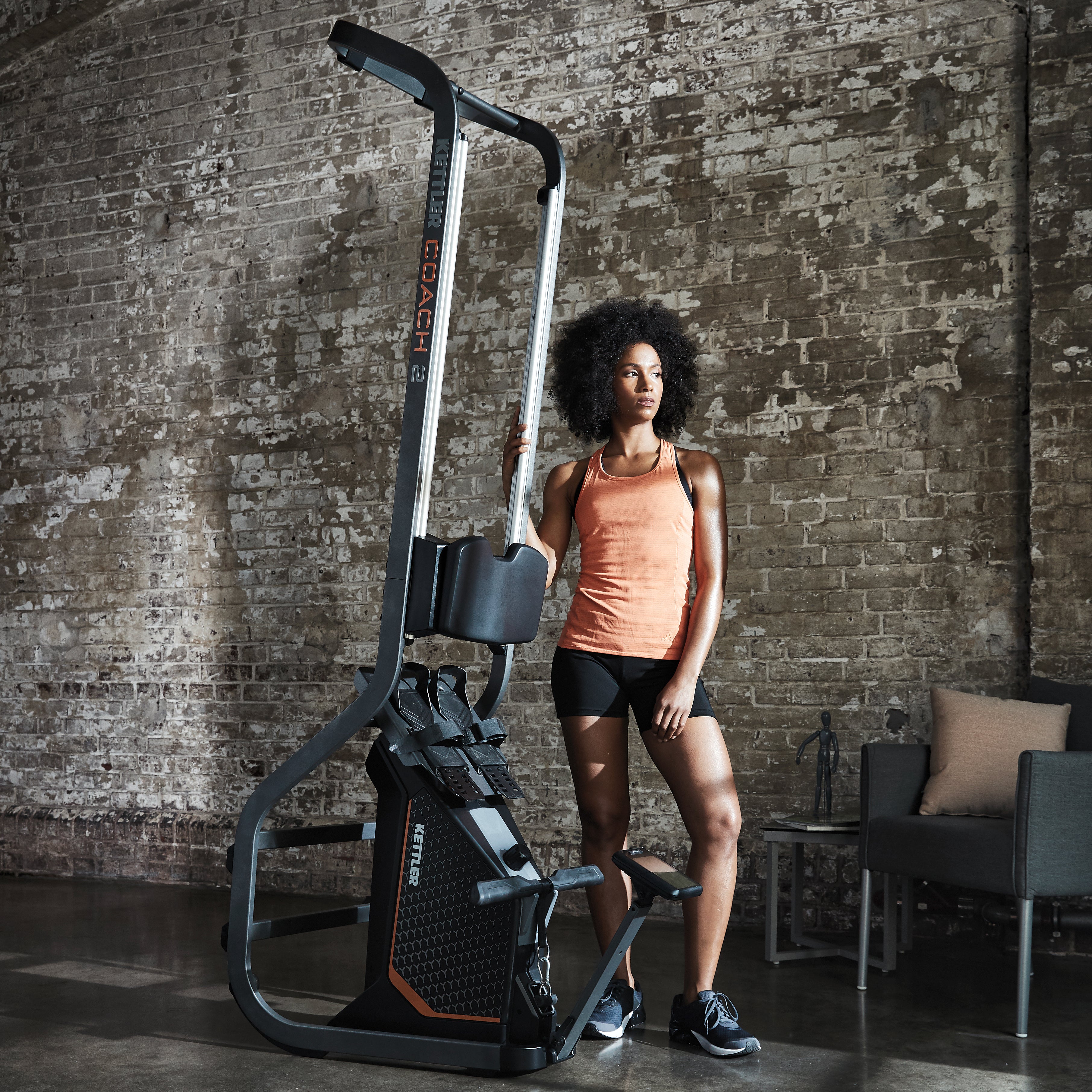 Lifestyle image of the Coach 2 Rowing Machine stored with model standing next to it. 