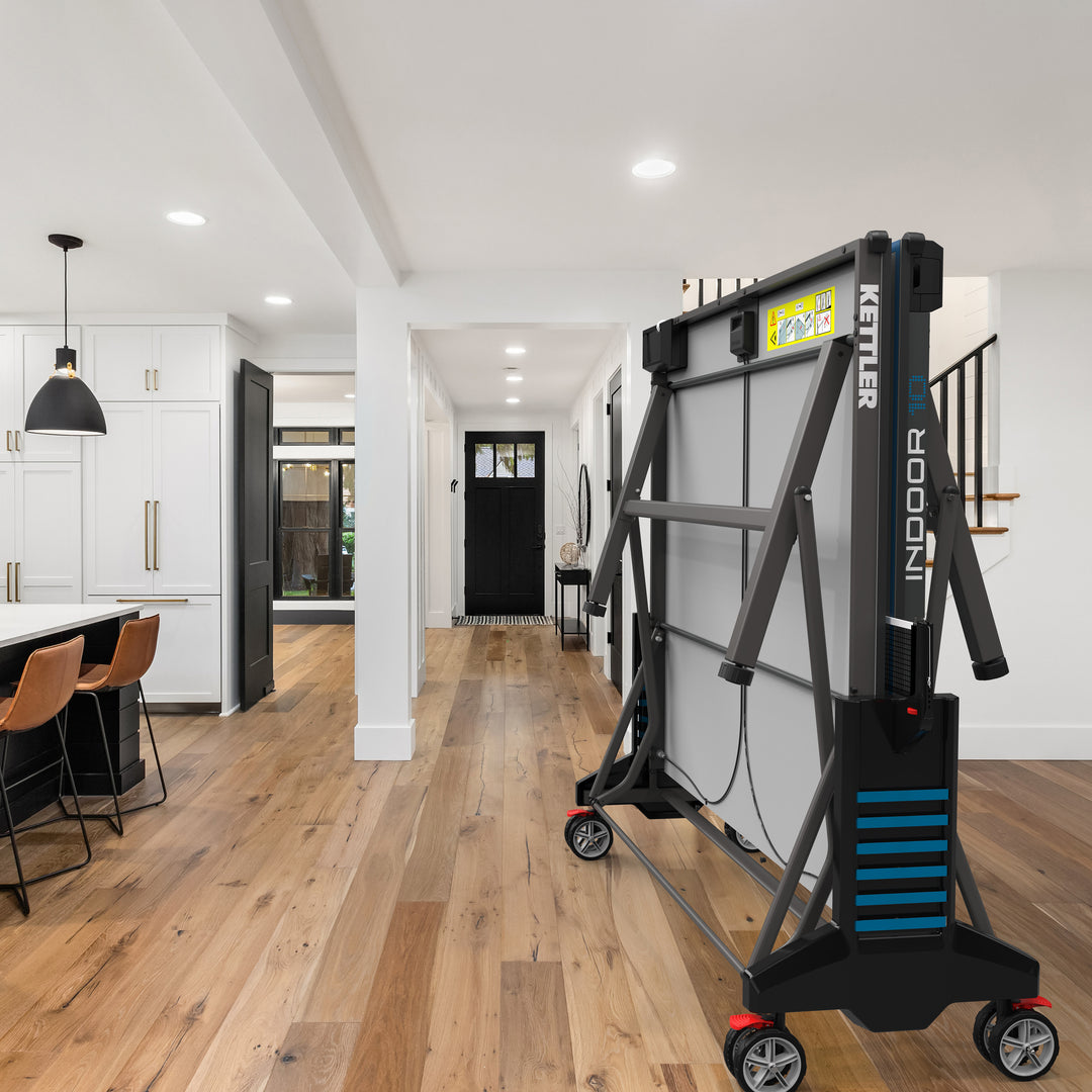 Indoor 10 Table Tennis Table folded in modern kitchen with easy storage, large wheels, and durable IN-TEC25 playfield.