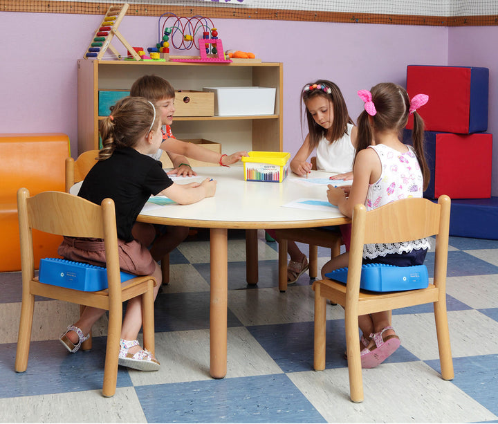 Children sitting on chairs using Gymnic Movin' Sit Jr. inflatable cushions to promote proper posture and focus in a classroom.
