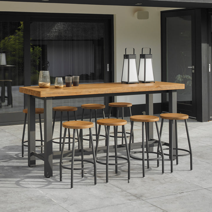 Canada Bar Height Dining Set with teak tops and lava powder-coated aluminum frame on patio with stools.