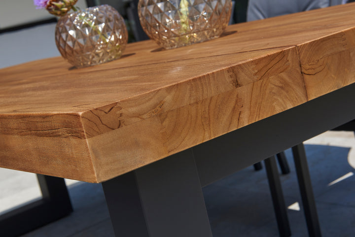 Close-up of the teak top and sturdy aluminum frame of the Canada Bar Height Dining Set with decorative vases on top
