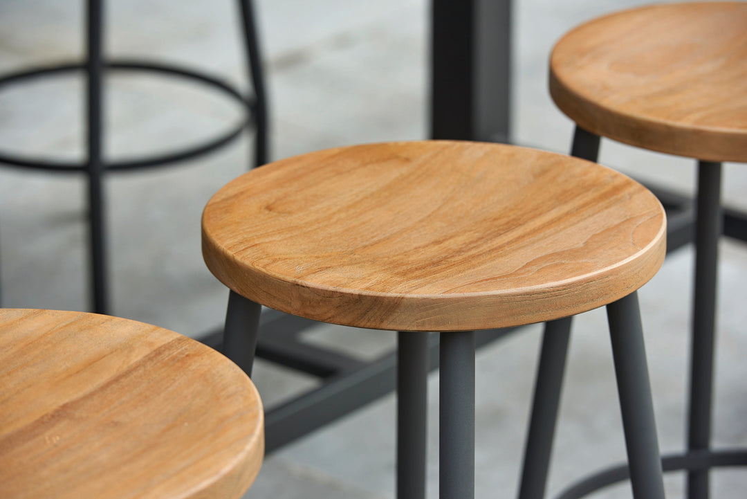 Close-up of teak seats and black metal legs on Canada Bar Height Dining Set stools.