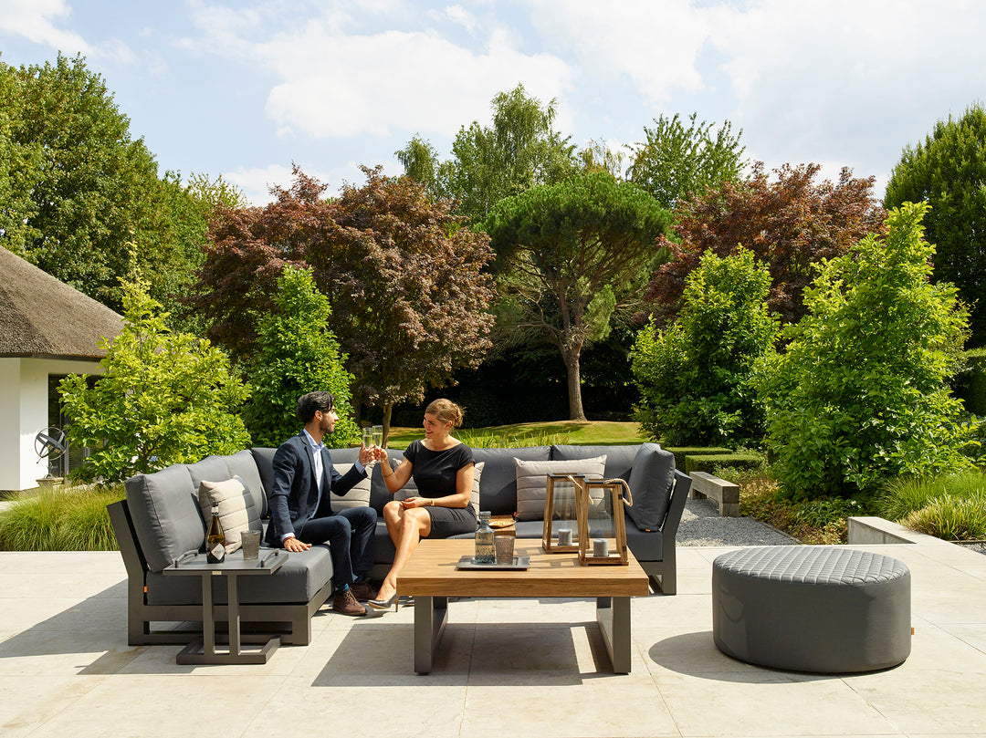 Nevada Corner Chair with carbon Textilene sling, canvas soot cushions, and powder-coated aluminum frame in outdoor patio setting.