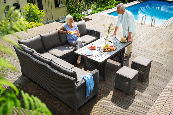 Palma Modular Wicker Right Arm Chair as part of outdoor dining set with gray cushions by pool deck.