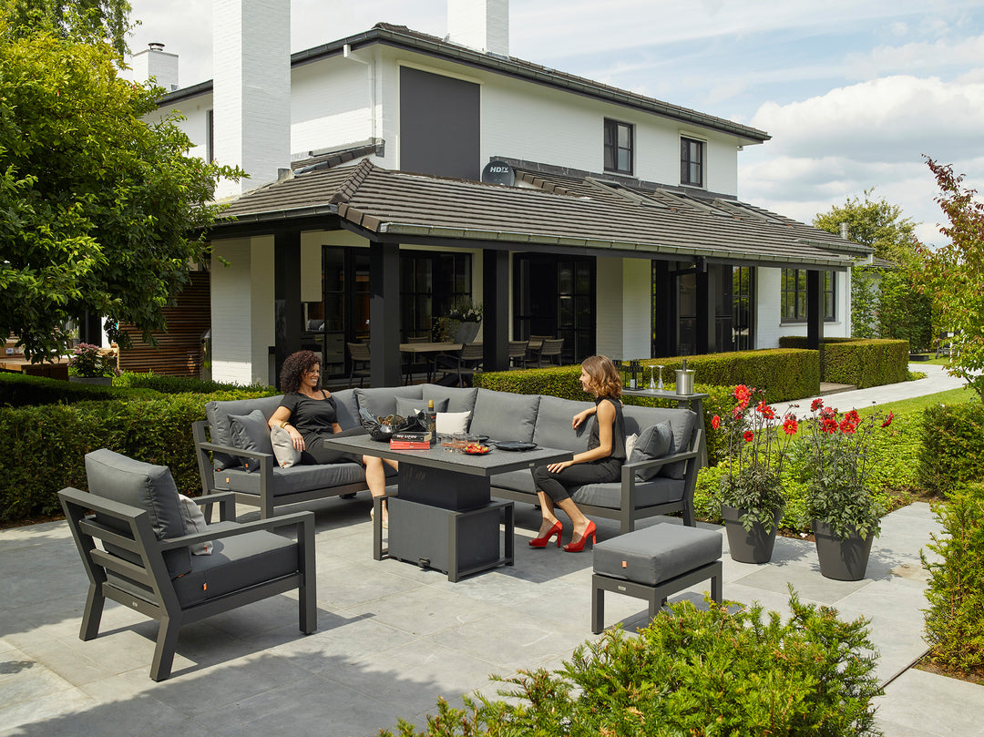 Timber Corner Chair set in outdoor patio with gray cushions and black frame, featuring a height-adjustable ceramic table.