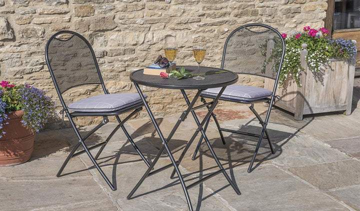 Cafe Napoli Wrought Iron 3-Piece Bistro Set with folding round table and two folding chairs in iron grey.